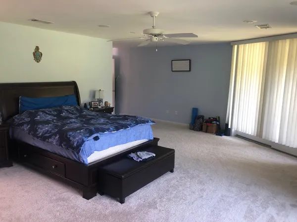a bed sitting in a bedroom next to a window