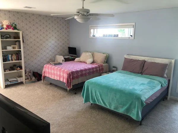 a bedroom with two beds and a chandelier