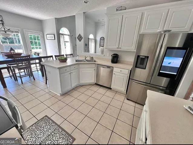 a kitchen with white cabinets and sink
