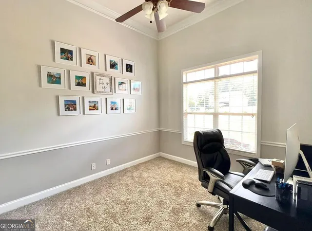 a view of a workspace with furniture and a window