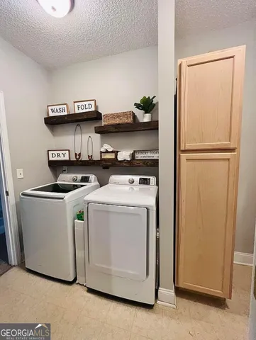 a utility room with stainless steel appliances washer and dryer
