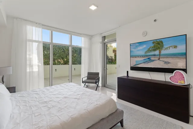 a bedroom with a bed and large windows