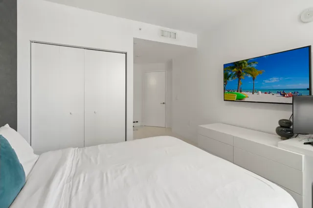 a bedroom with a bed and a painting on the wall