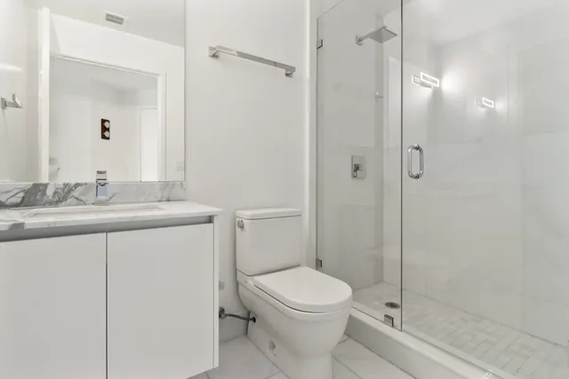 a bathroom with a sink a toilet and shower