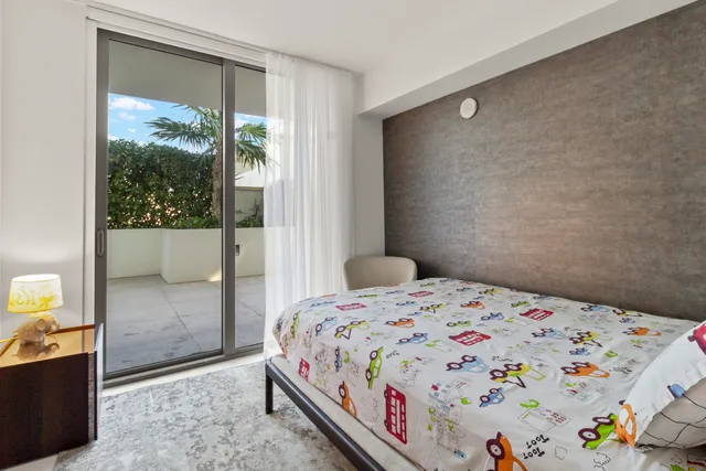 a bedroom with a bed and a dresser next to a window