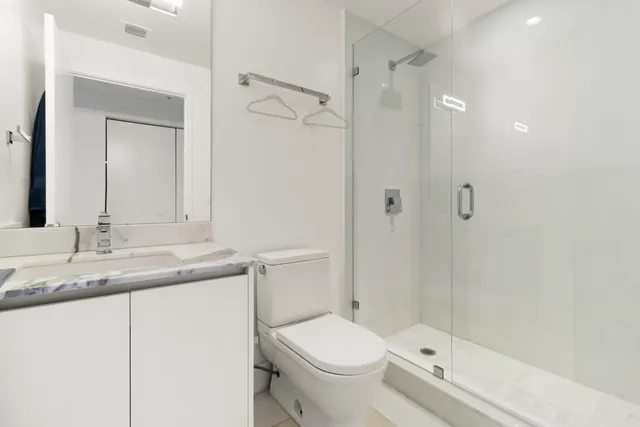 a bathroom with a granite countertop sink toilet and shower