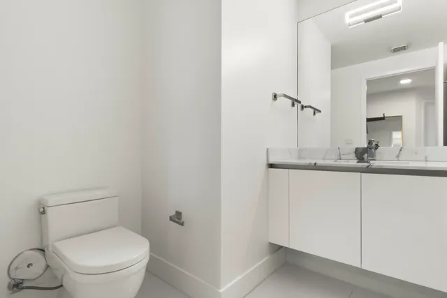 a bathroom with a toilet a sink and mirror