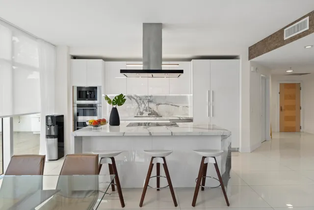 a kitchen with kitchen island granite countertop a table and chairs in it