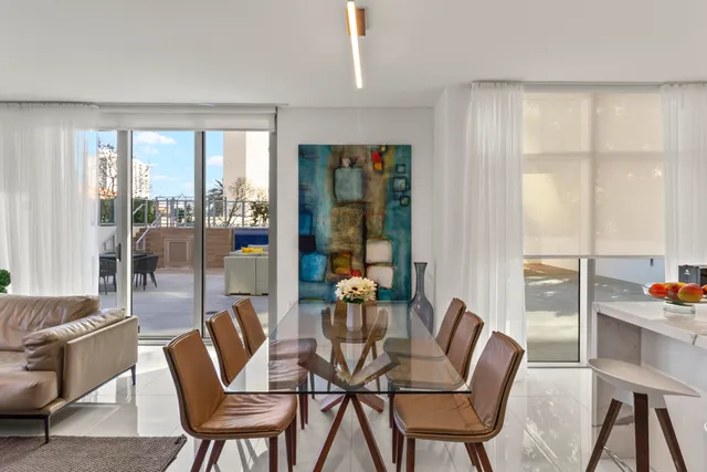 a dining room with furniture and large windows