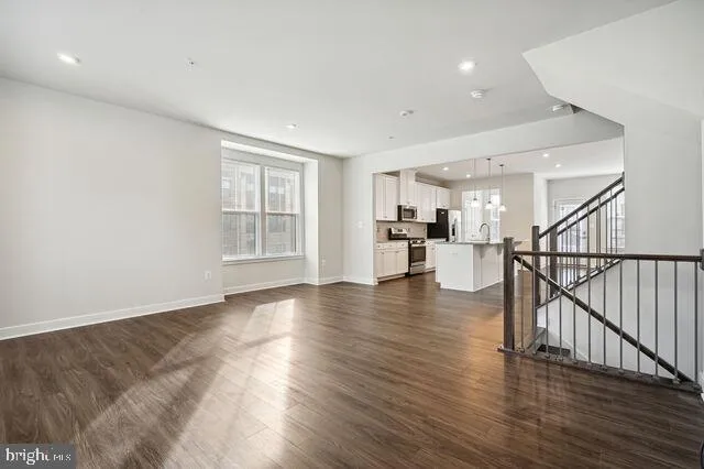 a view of a livingroom with wooden floor and stairs