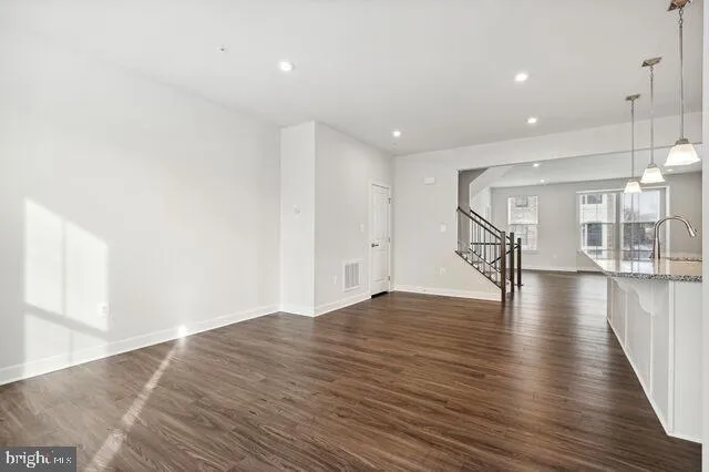 a kitchen with stainless steel appliances granite countertop a sink a stove and a wooden floors