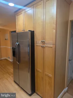 a view of a refrigerator in kitchen and a glass window