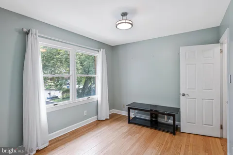 a view of room with window and wooden floor