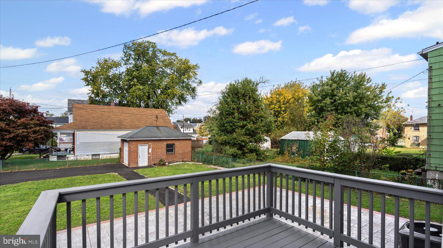 5300 Greenhill Avenue Baltimore, MD 21206 - Photo 14 of 43 a view of a white house with a large tree and wooden fence