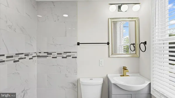 a bathroom with a sink a toilet and a mirror