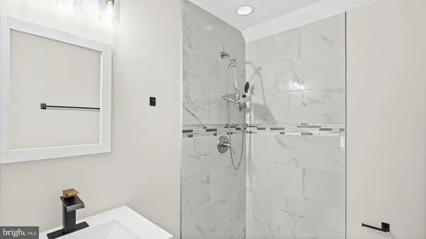 a bathroom with a sink a mirror and shower