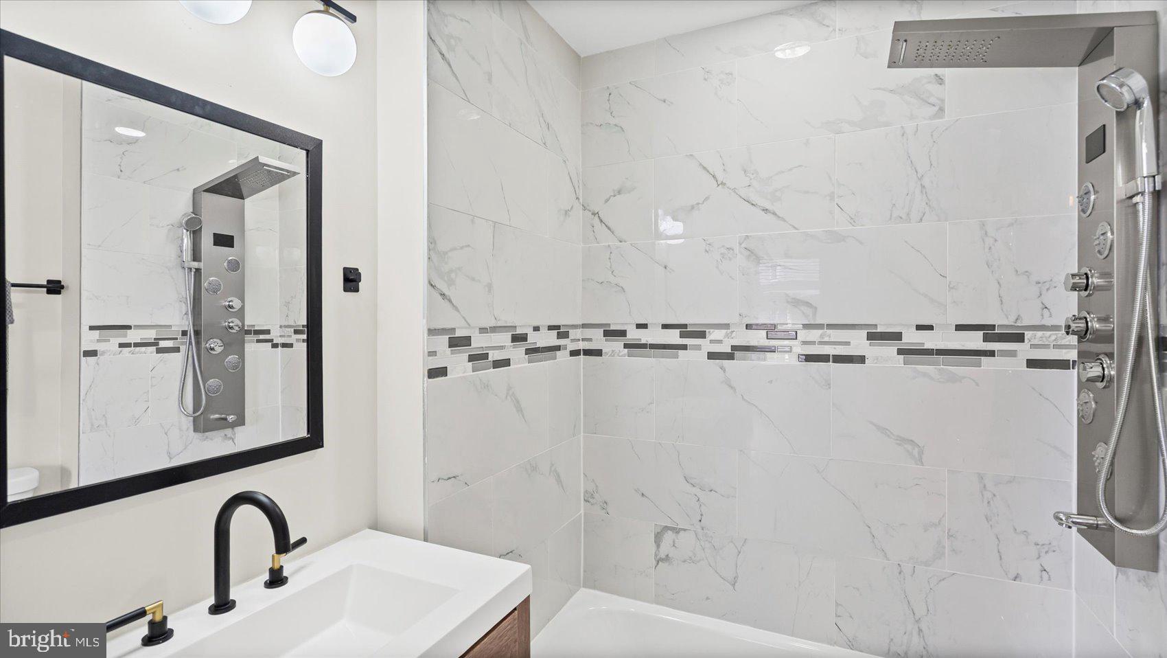 5300 Greenhill Avenue Baltimore, MD 21206 - Photo 37 of 43 a bathroom with a sink a mirror and shower