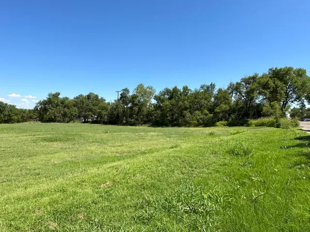 a view of a green field with wooden fence