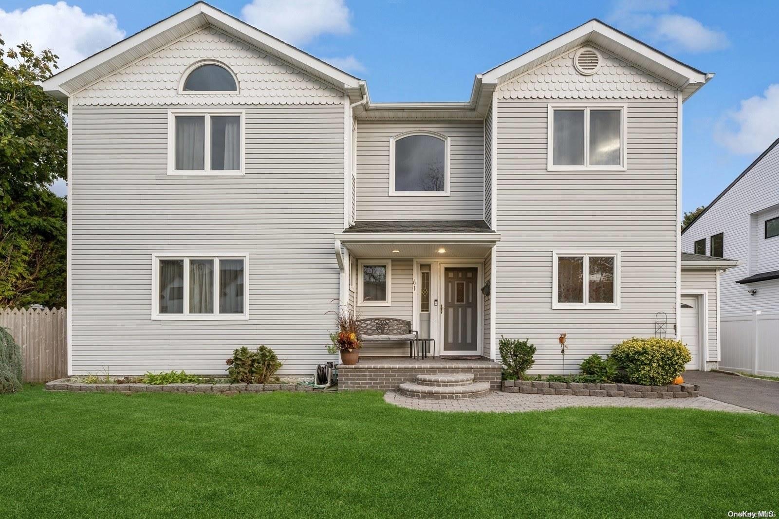 a front view of a house with a yard and trees