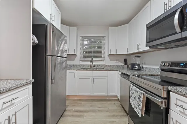 a kitchen with stainless steel appliances granite countertop a refrigerator sink and stove