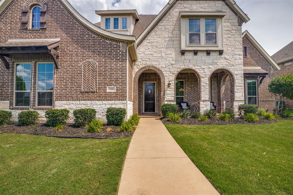 388 Bethany Road Sunnyvale, TX 75182 - Photo 4 of 40 Brick and stone exterior featuring an arched entryway and a prominent dormer