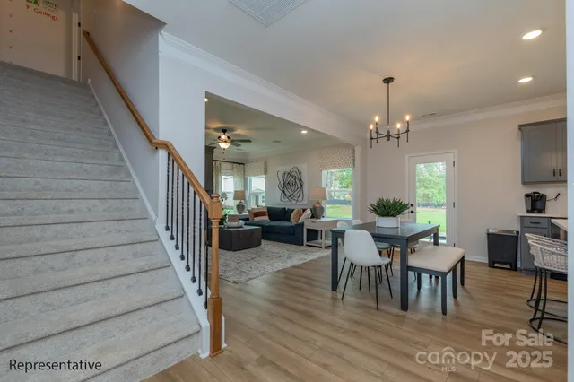 a view of a dining room with furniture a rug and wooden floor
