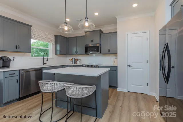 a kitchen with stainless steel appliances granite countertop a sink refrigerator and cabinets