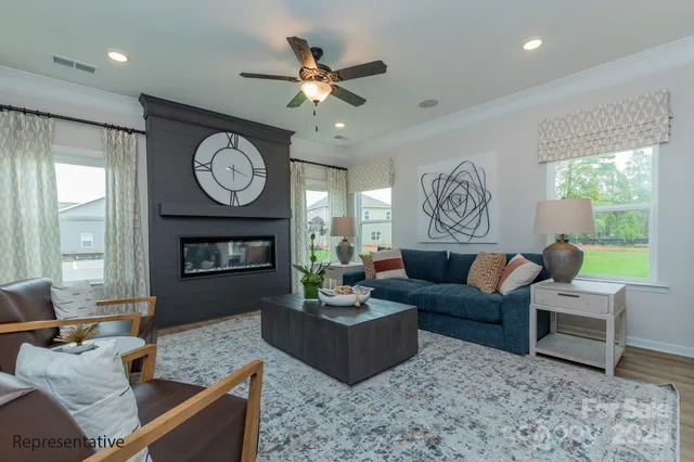 a living room with furniture a fireplace and a large window