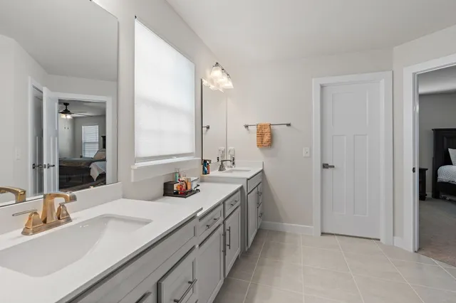 a bathroom with double sink and a mirror