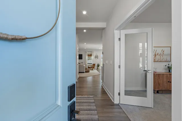 a view of a hallway view with wooden floor and living room