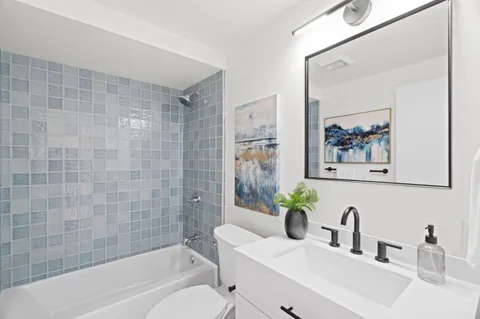 a bathroom with a sink mirror toilet and bathtub