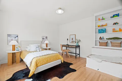 a bedroom with a bed wooden floor and lamp