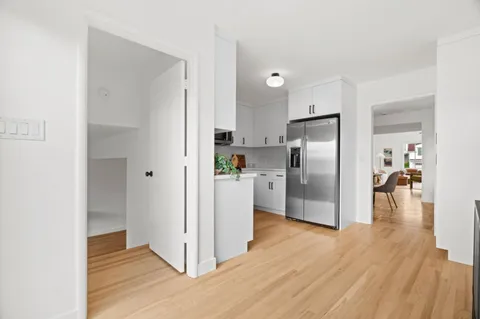 a kitchen with stainless steel appliances a refrigerator and a wooden floor