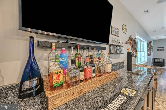 an empty room with a chandelier fan and windows