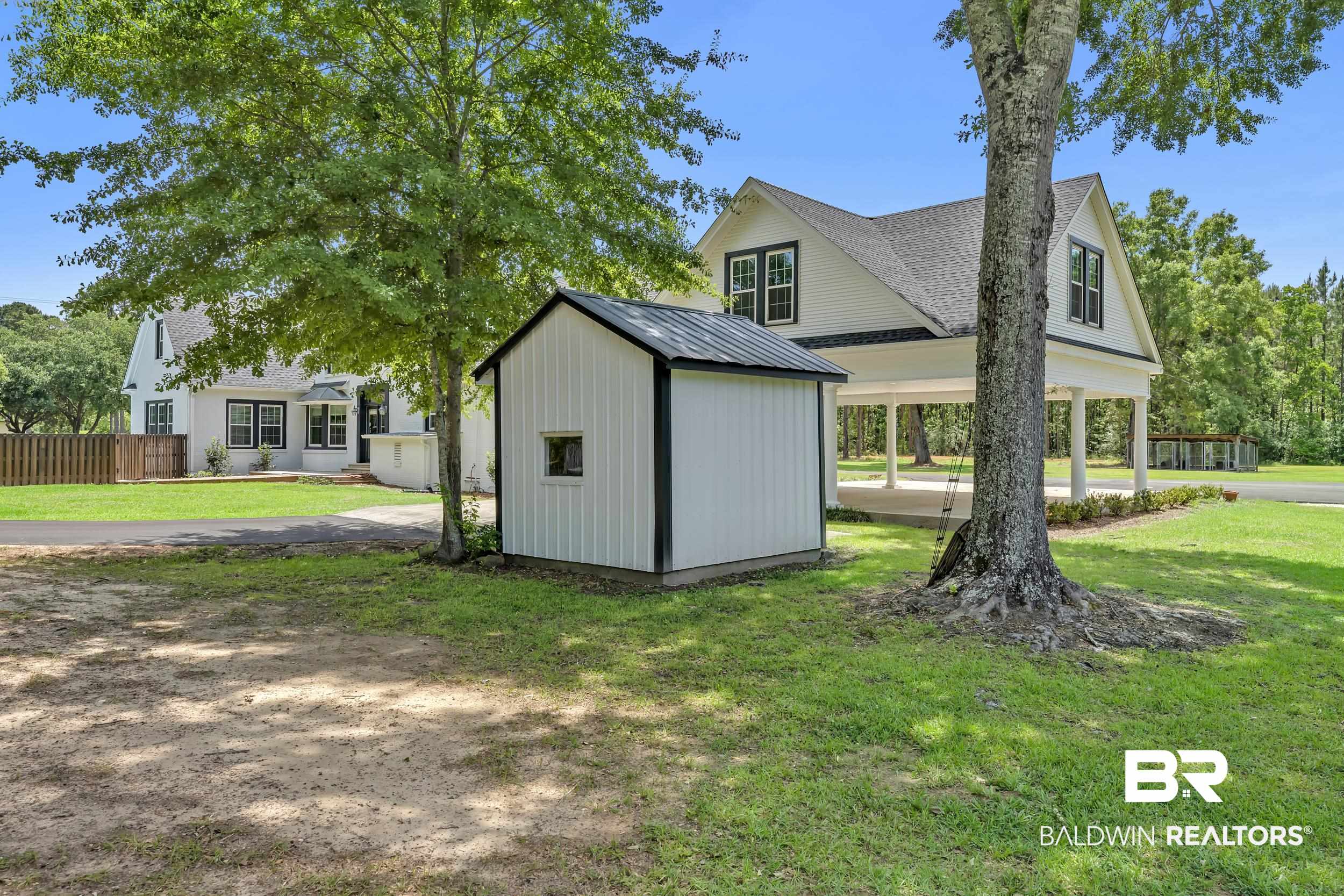 43199 Pine Grove Road Bay Minette, AL 36507 - Photo 16 of 71 Modern farmhouse exterior with a white facade, black trim windows, and a covered porch