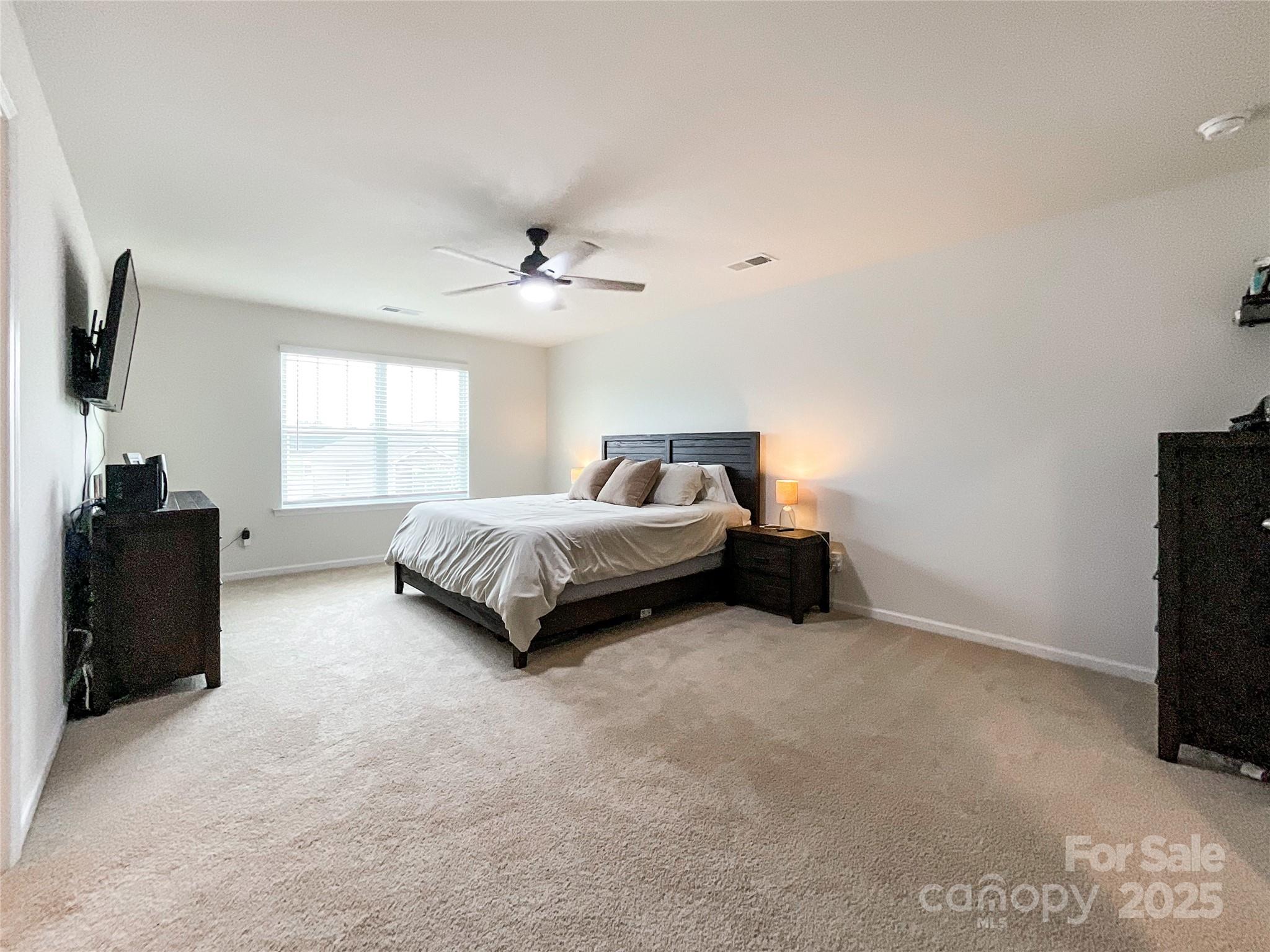 2159 Vanderlyn Street Monroe, NC 28112 - Photo 18 of 44 a spacious bedroom with a bed and a flat screen tv