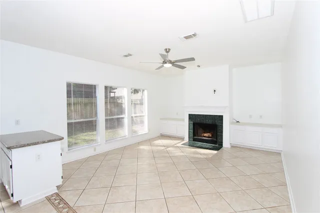 an empty room with a fireplace and windows