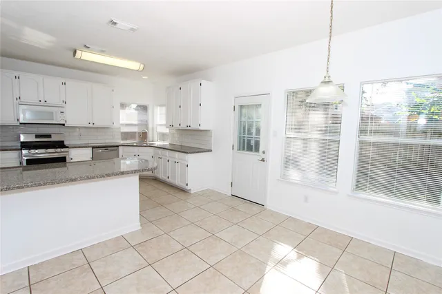 a kitchen with stainless steel appliances a refrigerator sink and cabinets