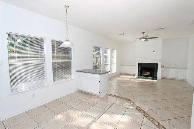 a large white kitchen with sink and a fireplace