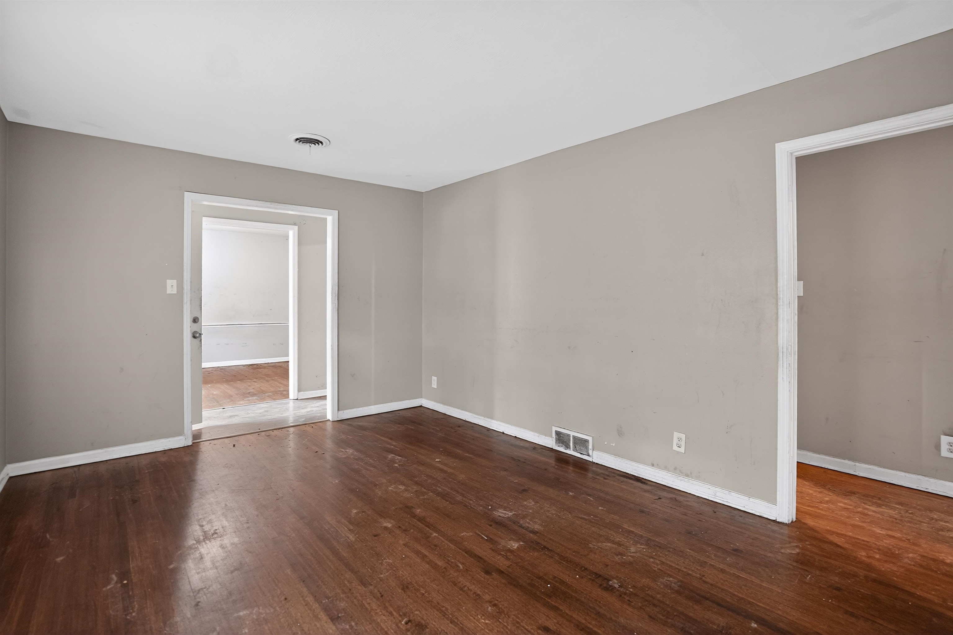 1890 Pennel Road Memphis, TN 38116 - Photo 6 of 25 Hardwood flooring throughout, neutral gray wall paint, white baseboards, and white trim around doorways