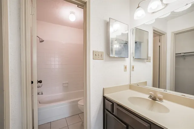 a bathroom with a granite countertop sink a toilet and shower