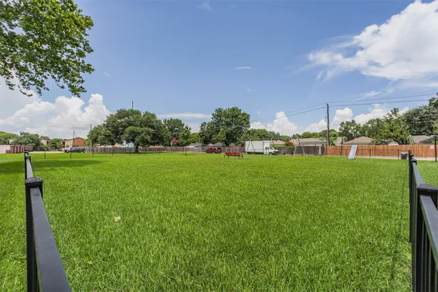 a view of a brick house with a yard and plants