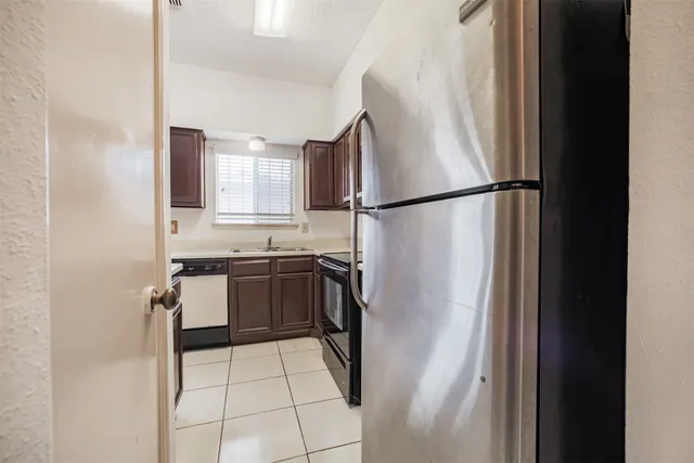 a kitchen with a refrigerator sink and cabinets