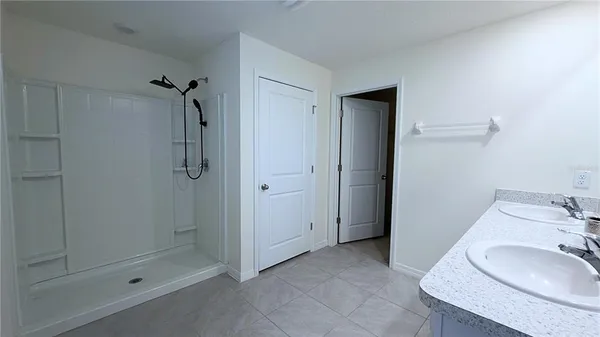 a bathroom with a granite countertop sink a mirror and shower