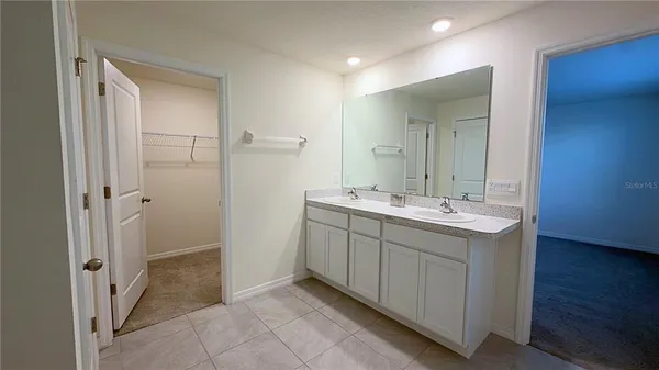 a bathroom with a double vanity sink and mirror