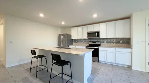 a kitchen with a sink a microwave and cabinets