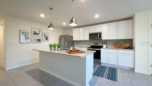 a kitchen with granite countertop a stove top oven and cabinets