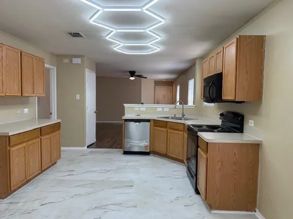 a large kitchen with stainless steel appliances granite countertop a stove sink and cabinets