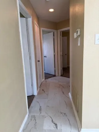 a view of a hallway with wooden shelves