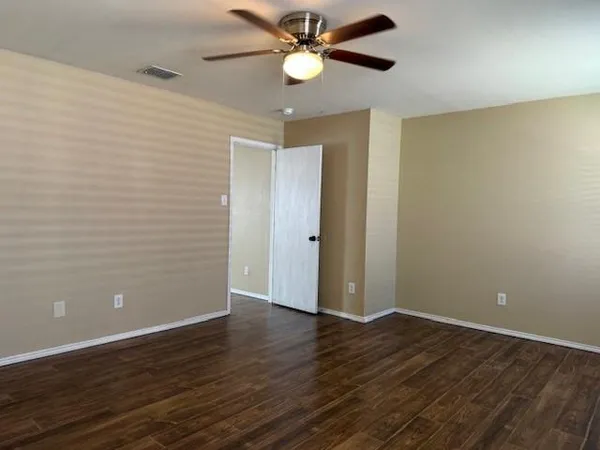 a view of an empty room with wooden floor